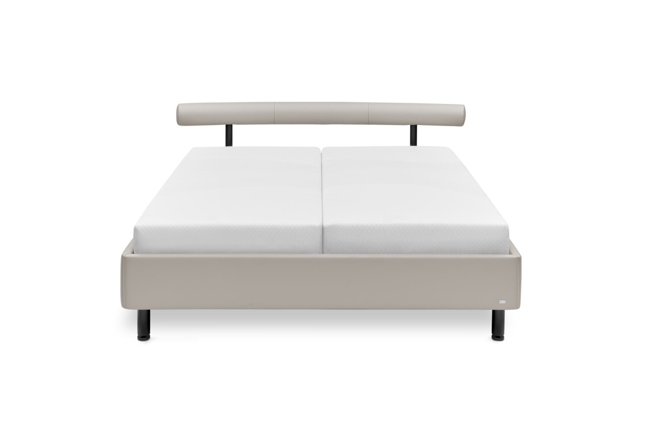 Frontale Ansicht eines modernen Polsterbetts mit hellem Bezug und schlichtem Design.