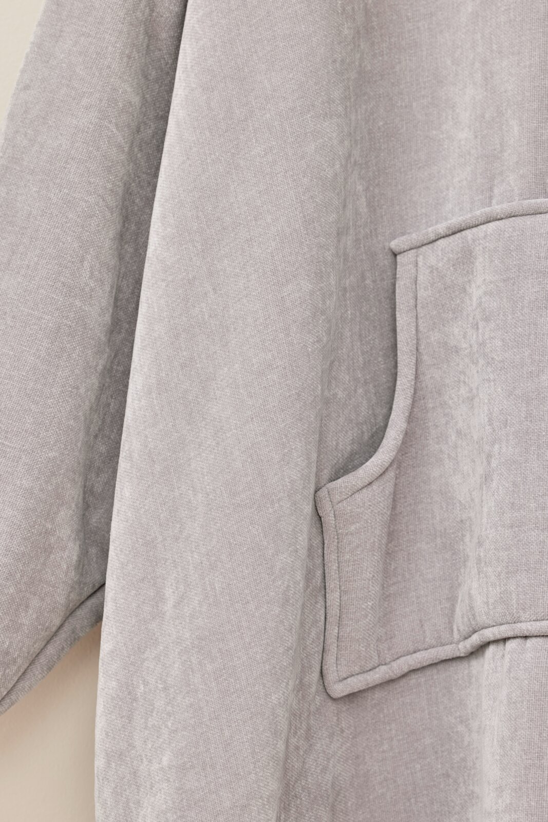Grauer Lounge-Hoodie aus weichem Stoff mit Kängurutasche, seitliche Perspektive