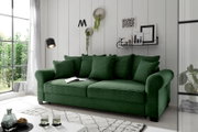 Grünes Funktionssofa mit mehreren Kissen, seitliche Perspektive, in einem modernen Wohnzimmer mit großen Fenstern und stilvoller Dekoration.