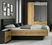 Modernes Schlafzimmer-Set mit Bett in Eiche-Optik und schwarzem Polsterkopfteil, passendem Nachttisch und Kleiderschrank mit Spiegel-Schiebetüren, frontal aus leicht seitlicher Perspektive fotografiert