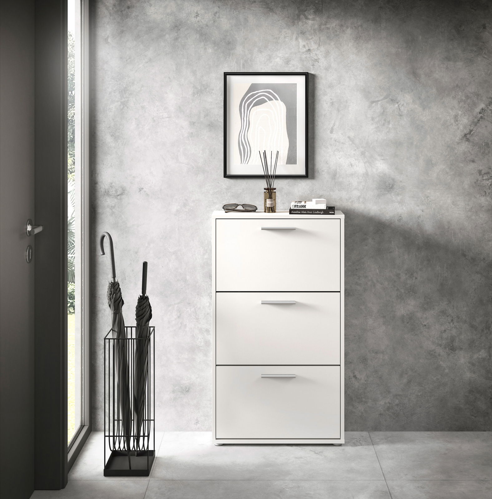 Moderner weißer Schuhkipper mit drei Klappen, frontal fotografiert, neben einem Regenschirmständer in einem stilvollen Eingangsbereich.