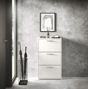 Moderner weißer Schuhkipper mit drei Klappen, frontal fotografiert, neben einem Regenschirmständer in einem stilvollen Eingangsbereich.