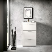 Moderner weißer Schuhkipper mit drei Klappen, frontal fotografiert, neben einem Regenschirmständer in einem stilvollen Eingangsbereich.