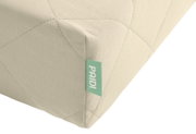 Close-up zijaanzicht van een lichtbeige, doorgestikte kussenhoek met groen PAIDI-label