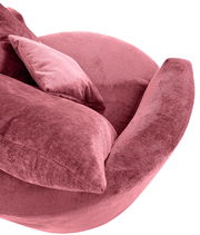 Nahaufnahme eines rosafarbenen Sessels mit weichem Stoffbezug und passendem Kissen, seitliche Perspektive