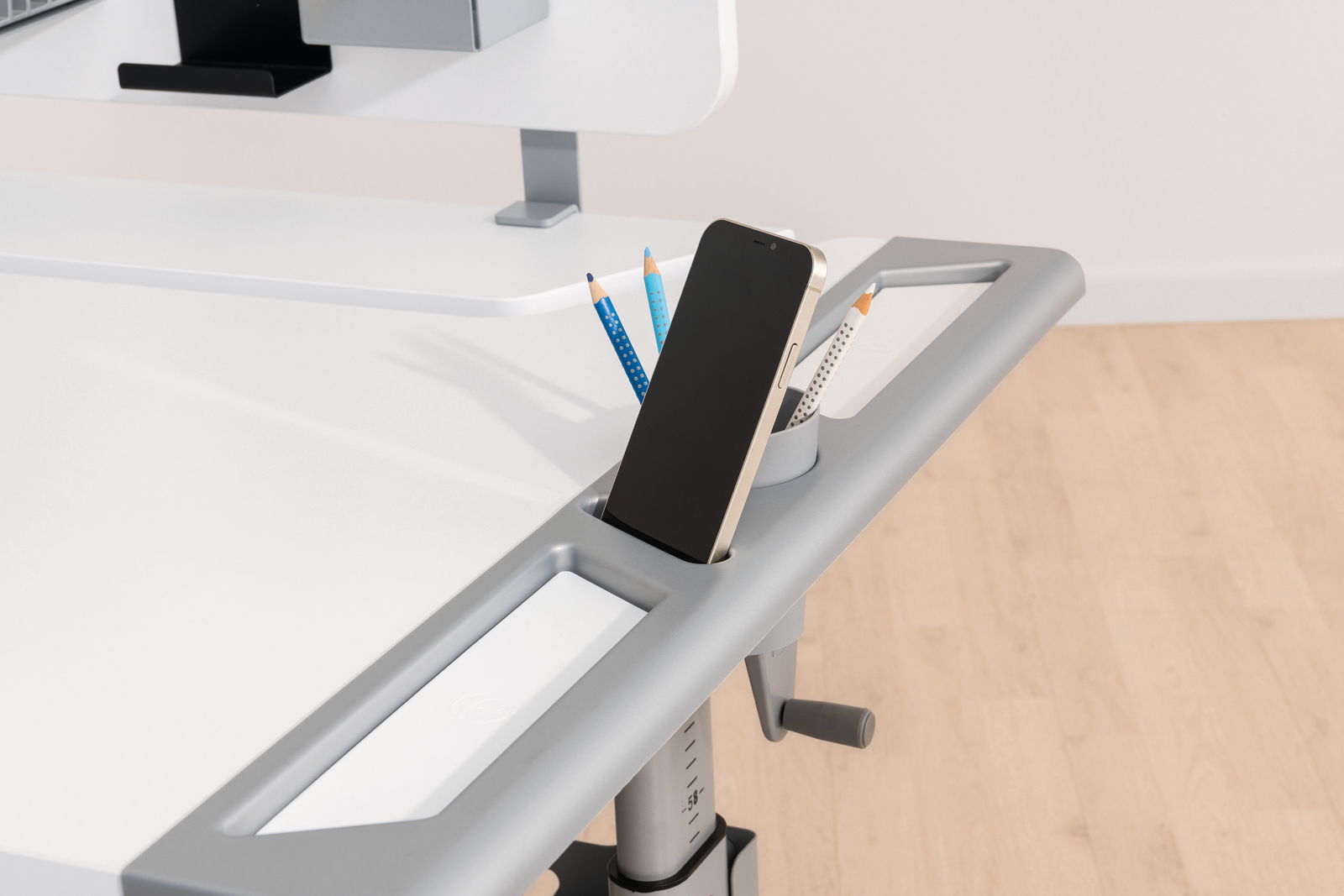 Moderner Schreibtisch mit integriertem Smartphone-Halter und Stiftehalter, seitliche Perspektive