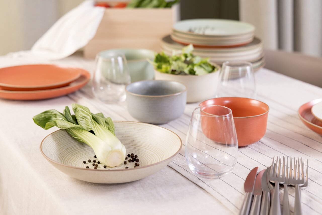 Thomas Suppenteller NATURE Suppenteller 23 cm auf einem gedeckten Tisch, gefüllt mit Pak Choi und Pfefferkörnern, aus einer seitlichen Perspektive fotografiert.