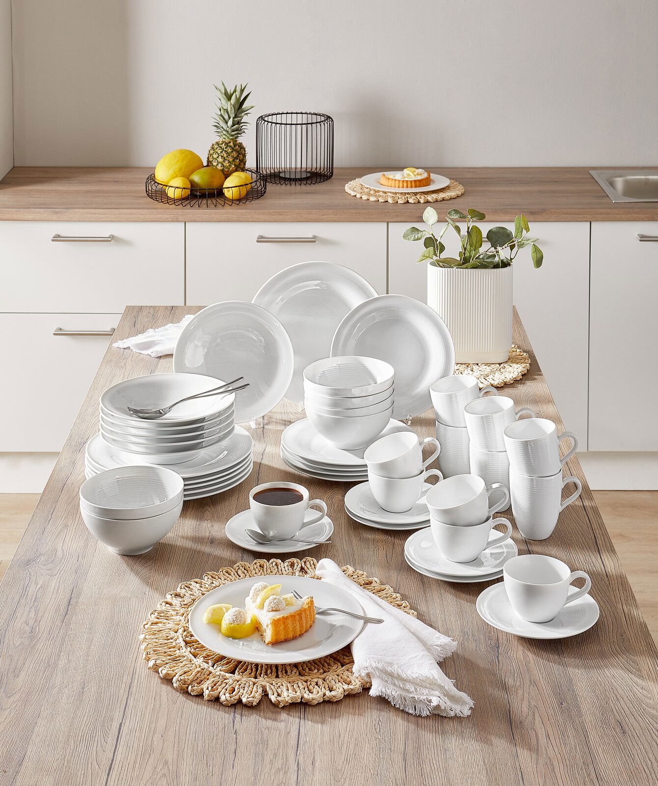 Seltmann Weiden Kombiservice 42-tlg. BEAT Kombiservice Beat 42-tlg. in einer modernen Küche, von oben fotografiert. Das Set umfasst Teller, Schalen und Tassen in elegantem Weiß, arrangiert auf einem Holztisch.