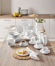 Kombiservice Beat 42-tlg. in einer modernen Küche, von oben fotografiert. Das Set umfasst Teller, Schalen und Tassen in elegantem Weiß, arrangiert auf einem Holztisch.