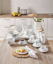 Kombiservice Beat 42-tlg. in einer modernen Küche, von oben fotografiert. Das Set umfasst Teller, Schalen und Tassen in elegantem Weiß, arrangiert auf einem Holztisch.