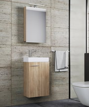 Modernes, wandhängendes Badmöbel-Set mit Waschtischunterschrank in heller Holzoptik, weißem Aufsatzwaschbecken, Spiegelschrank und LED-Aufbauleuchte; Ansicht schräg von vorn im Badezimmer.