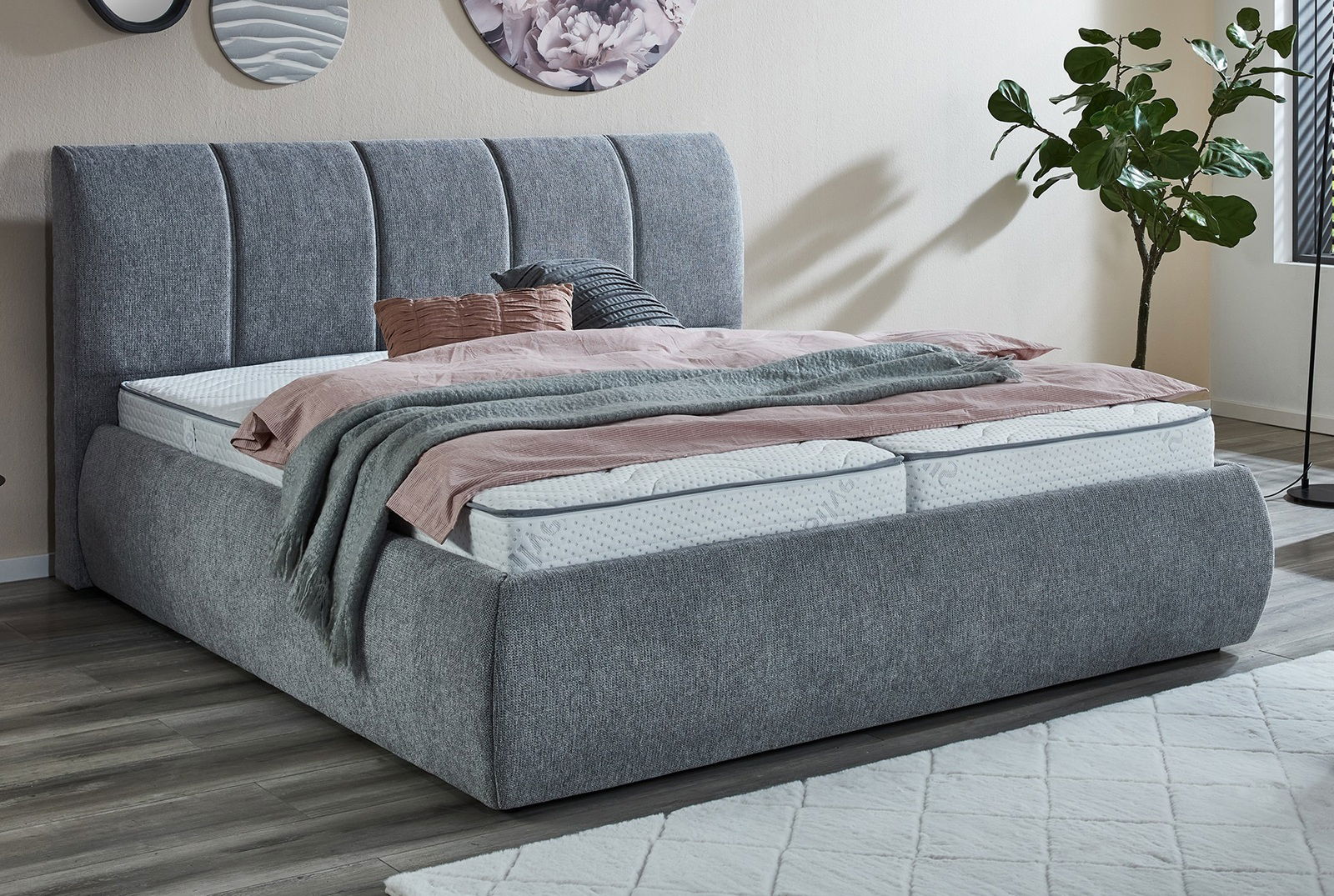 Graues Polsterbettgestell in einem modernen Schlafzimmer, seitliche Perspektive