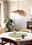 Pendelleuchte SIRUELA in einem modernen Esszimmer, aus der Perspektive von schräg unten fotografiert, mit einem runden Tisch und Pflanzen im Hintergrund.