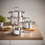 Topfset Charm 4-tlg. aus Edelstahl, bestehend aus drei Töpfen und einer Stielkasserolle, auf einem Holztisch von schräg oben fotografiert.