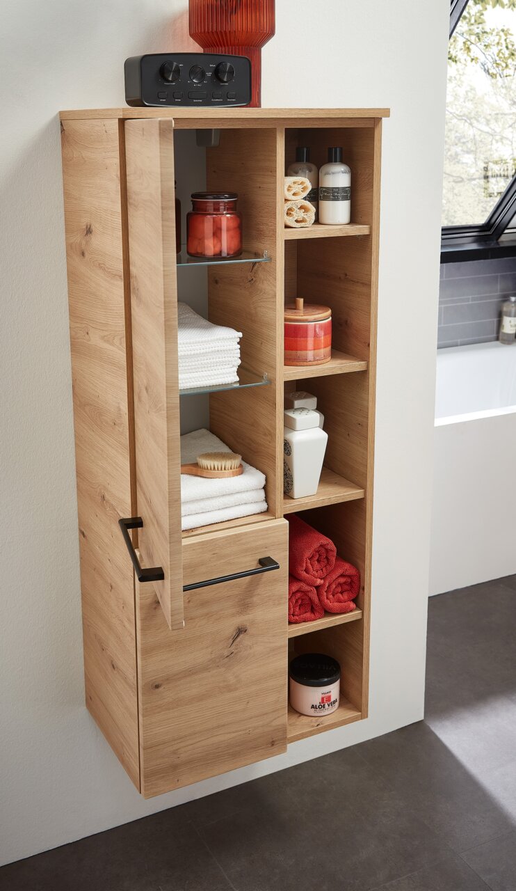 Moderner Midischrank aus Holz mit offenen und geschlossenen Fächern, gefüllt mit Handtüchern und Pflegeprodukten, aus seitlicher Perspektive.