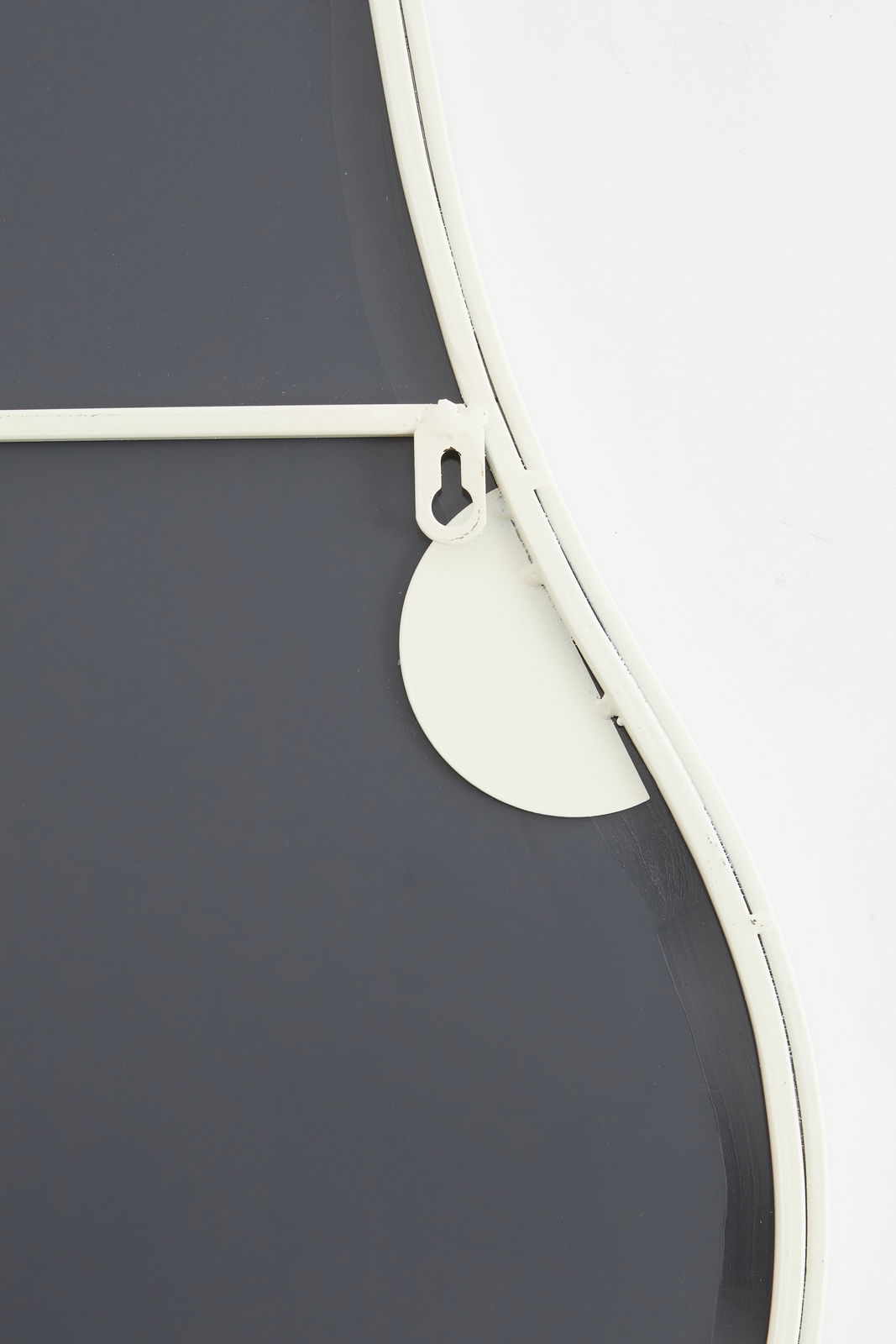 Rückansicht eines Spiegels mit weißem Rahmen und Aufhängung.