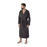 Mann in einem dunkelgrauen Kapuzenbademantel, Größe M, steht barfuß und blickt zur Seite. Frontalansicht.