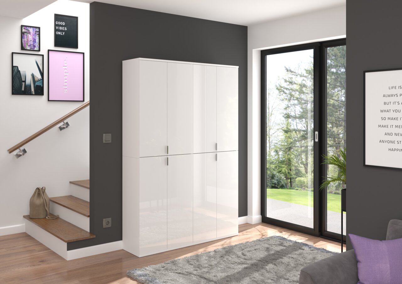 Moderner weißer Hochschrank mit glänzender Oberfläche, in einem stilvollen Wohnzimmer mit großen Fenstern und dekorativen Bildern an der Wand, aus seitlicher Perspektive.