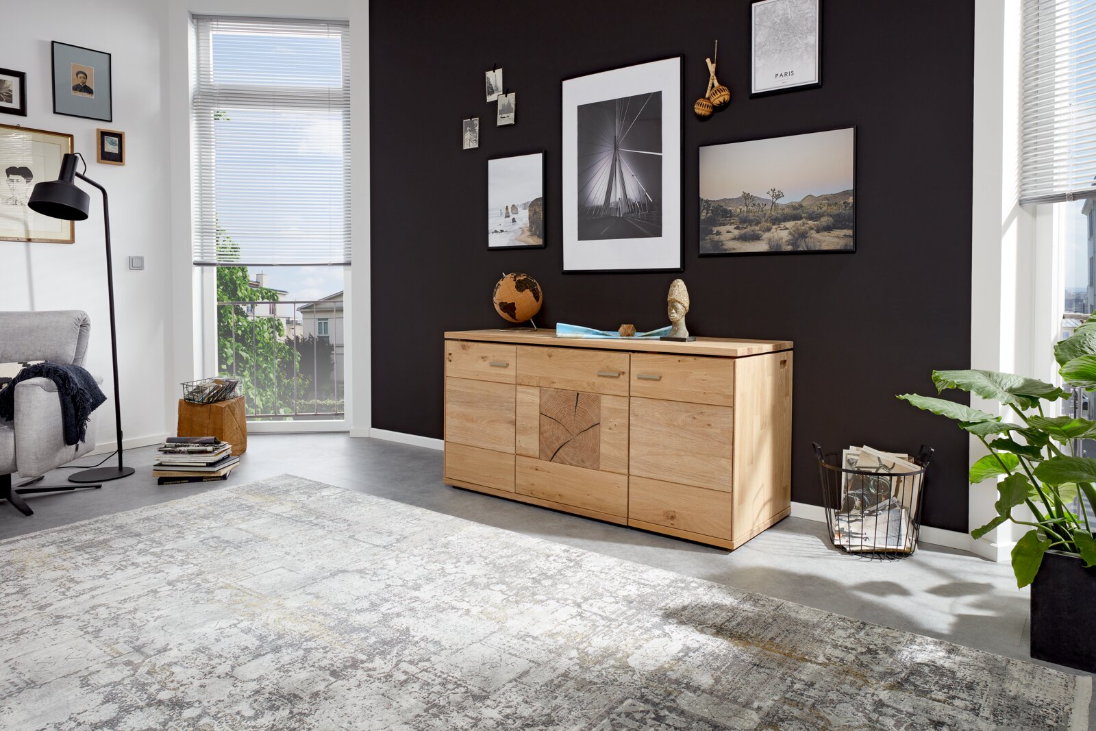 Holz-Sideboard in einem modernen Wohnzimmer, frontal fotografiert, mit Dekorationen und Wandbildern im Hintergrund.