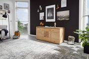 Holz-Sideboard in einem modernen Wohnzimmer, frontal fotografiert, mit Dekorationen und Wandbildern im Hintergrund.