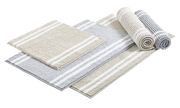 Set aus gestreiften Badematten in Beige und Grau, teilweise gerollt, aus seitlicher Perspektive fotografiert.