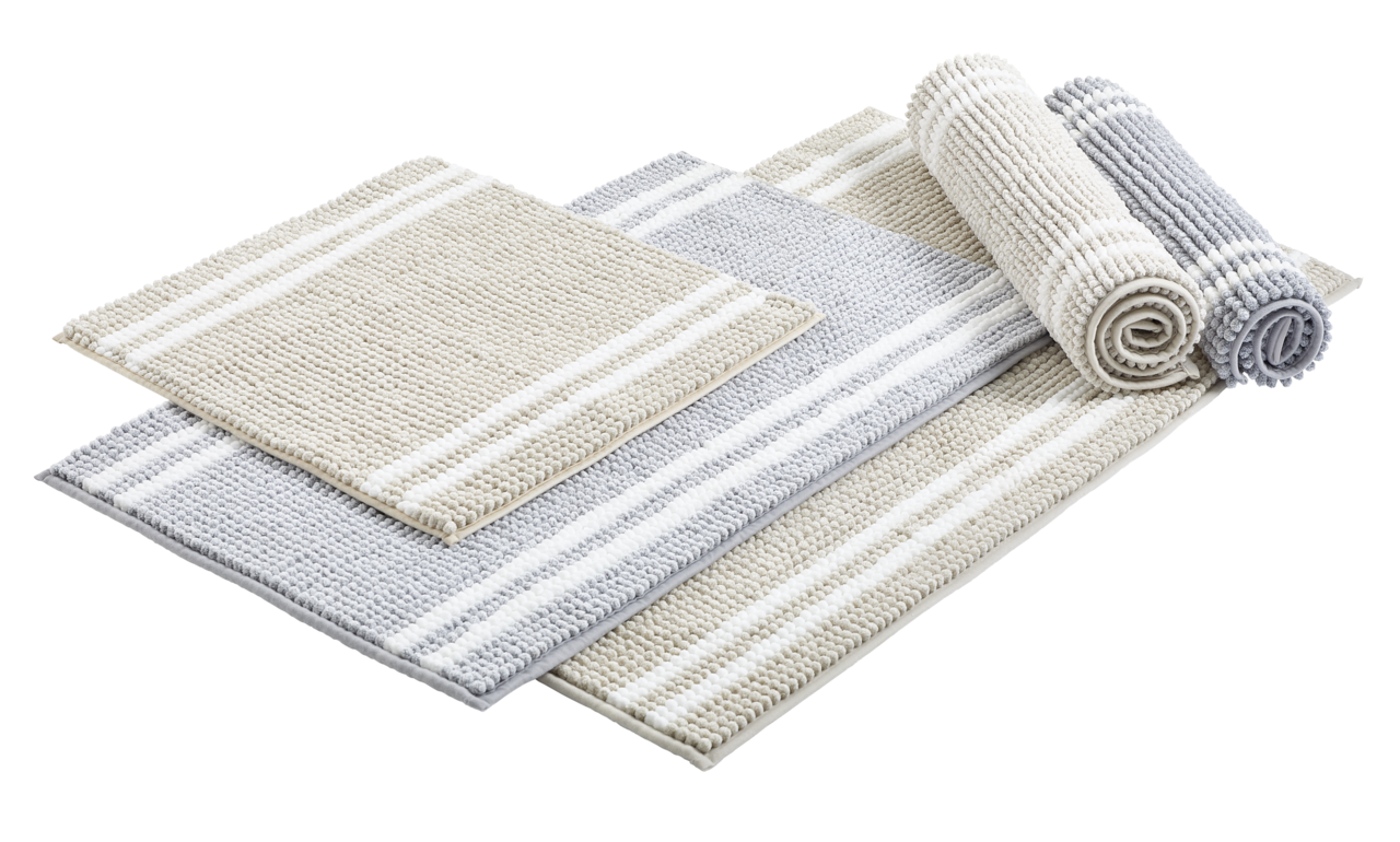 Set aus gestreiften Badematten in Beige und Grau, teilweise gerollt, aus seitlicher Perspektive fotografiert.