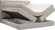 Beiges Boxspringbett mit gepolstertem Kopfteil und geteilter, motorisch verstellbarer Liegefläche; Matratze teilweise angehoben, Stauraum im Bettkasten sichtbar – Seitenansicht in leichter Schrägperspektive.