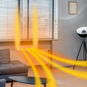 Heizkörper mit Invictus Therma Boost, der warme Luft in einem modernen Wohnzimmer verteilt, seitliche Perspektive