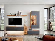 Moderne woonkamer met een wandplank in houtlook, versierd met boeken en kaarsen, met op de achtergrond een grote televisie. Perspectief: vooraanzicht.