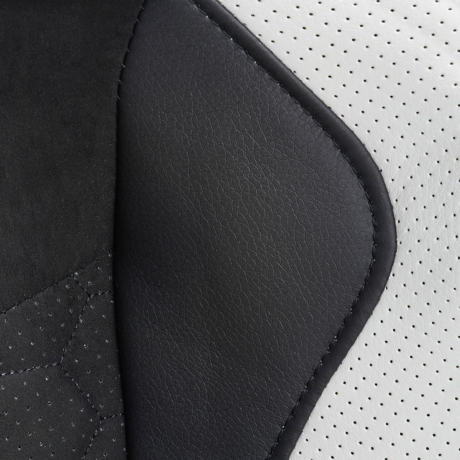 Nahaufnahme der Polsterung eines Gaming Stuhls mit schwarzem und weißem Kunstleder aus seitlicher Perspektive