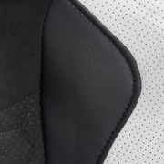 Nahaufnahme der Polsterung eines Gaming Stuhls mit schwarzem und weißem Kunstleder aus seitlicher Perspektive