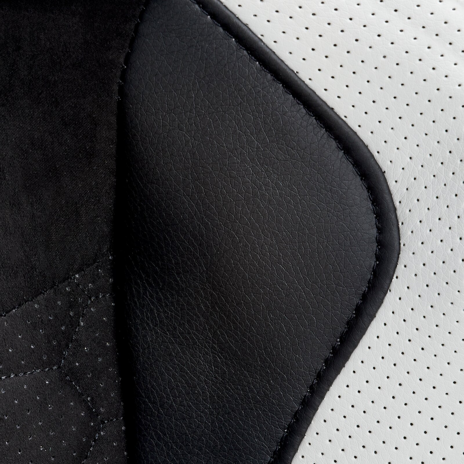 Close-up van de bekleding van een gamingstoel met zwart en wit kunstleer, gezien vanaf de zijkant