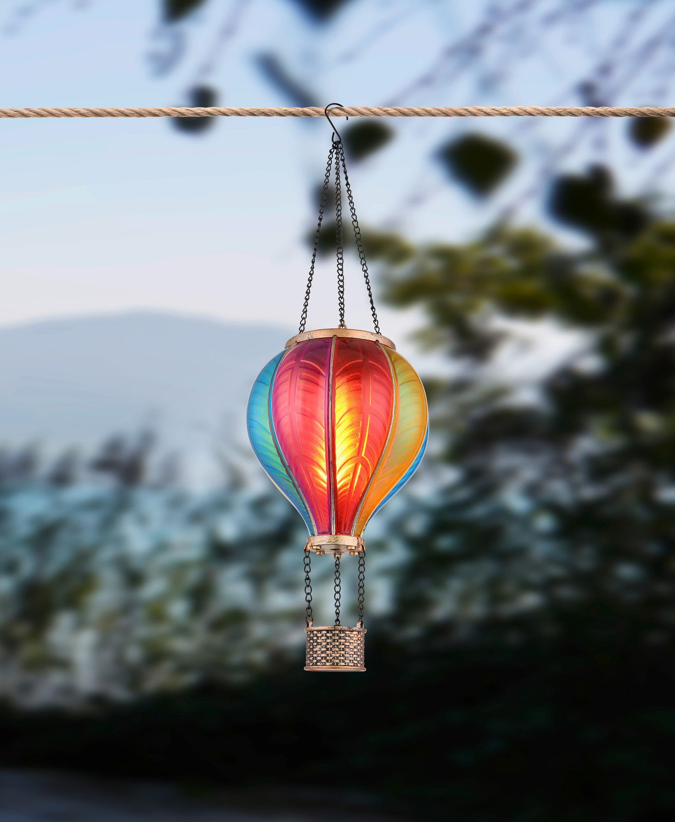 Bunte Solarleuchte in Form eines Heißluftballons, aufgehängt an einem Seil, seitliche Perspektive