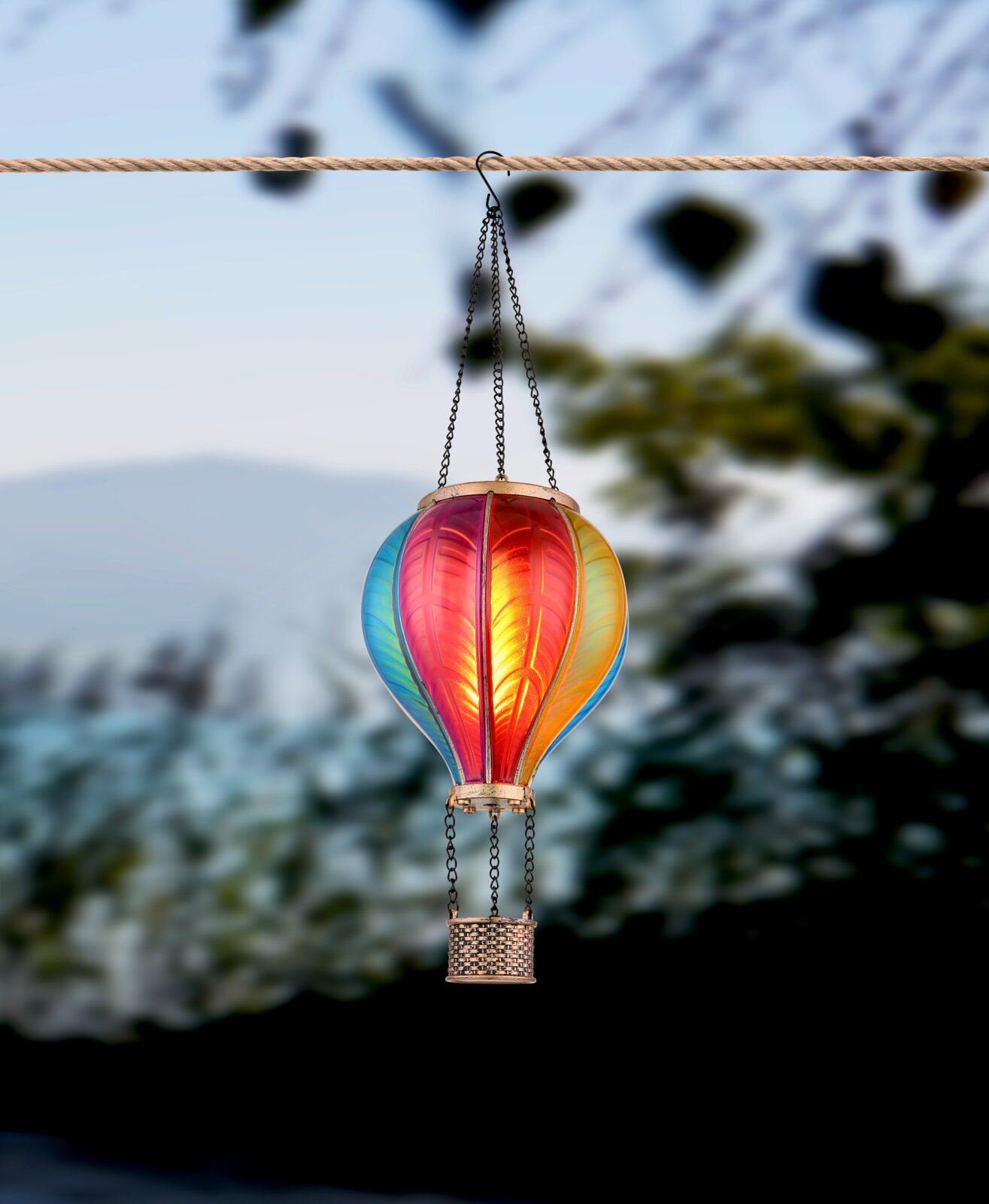 Bunte Solarleuchte in Form eines Heißluftballons, aufgehängt an einem Seil, seitliche Perspektive