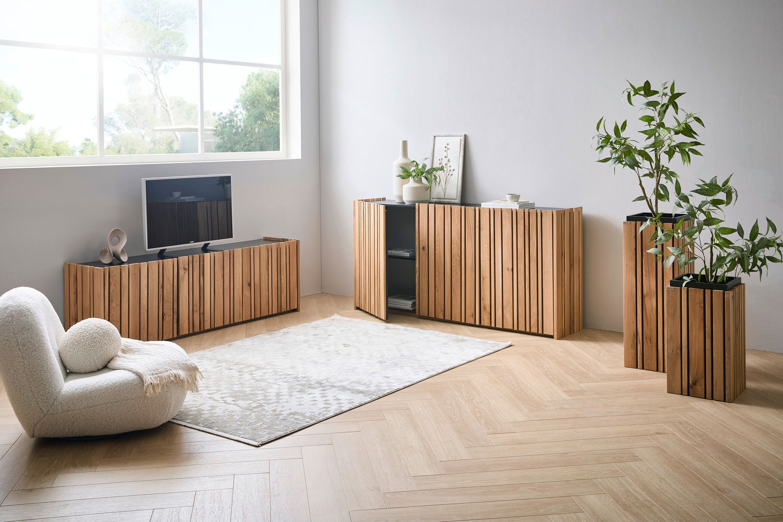 Moderner Wohnraum mit Sideboard und TV-Lowboard aus Holz in Frontansicht, dekoriert mit Pflanzen und Vasen.