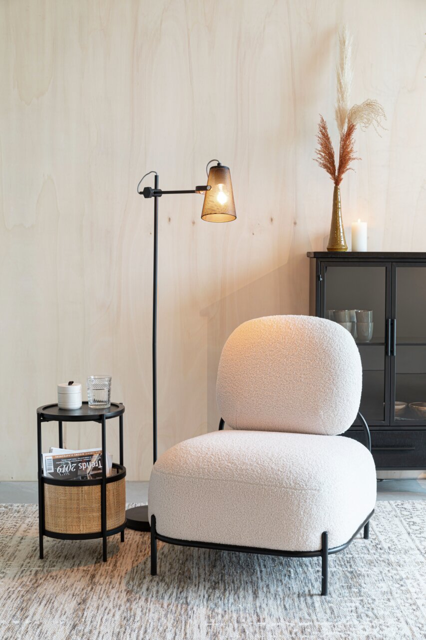 Z2 Beistelltisch MAKATO Beistelltisch MAKATO aus schwarzem Metall mit zwei Ebenen, eine mit Rattan-Elementen, im modernen Wohnzimmer neben einem Sessel, aus seitlicher Perspektive.