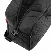 Schwarze Duffelbag mit Rautenmuster, Nahaufnahme von oben mit sichtbarem Reißverschluss und Tragegurt.