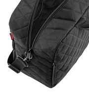 Schwarze Duffelbag mit Rautenmuster, Nahaufnahme von oben mit sichtbarem Reißverschluss und Tragegurt.