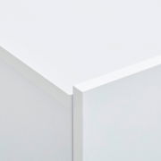 Nahaufnahme einer Ecke eines weißen Hängeschuhschranks, perspektivisch von oben fotografiert.