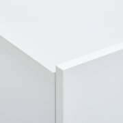 Close-up van een hoek van een witte hangende schoenenkast, vanuit een perspectief van bovenaf gefotografeerd.