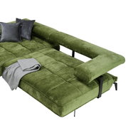 Groene longchair-set met een fluweelzacht oppervlak, twee grijze kussens en een grijze deken, gezien vanuit vogelperspectief.