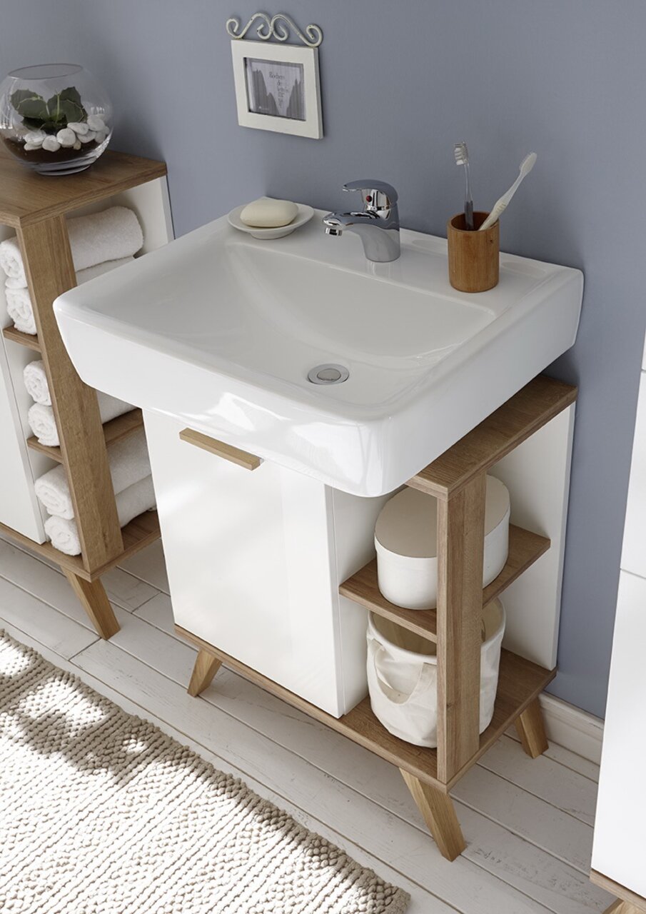 Moderne houten wastafelonderkast met witte wastafel, planken aan de zijkanten en decoratieve accessoires, gezien vanuit vogelperspectief.