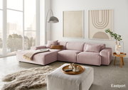 Moderne, große Ecksofa in Rosa mit gemütlichen Kissen, abgebildet in einem hellen Wohnzimmer mit großen Fenstern und stilvollen Wandbildern, aus der Perspektive von vorne links.