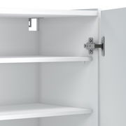 Innenansicht eines weißen XL-Schuhschranks mit zwei Regalböden und einer geöffneten Tür, die das Scharnier zeigt.