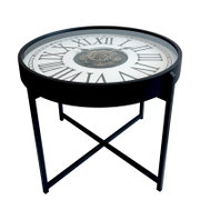 Ronde bijzettafel in zwart met een tafelblad in de vorm van een klok (Romeinse cijfers en zichtbaar uurwerk onder glas), afgebeeld in een schuin bovenaanzicht tegen een witte achtergrond.