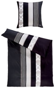 Bettwäsche-Set mit Kissen und Decke in Schwarz-Weiß mit Streifen- und Blumenmuster, aus der Vogelperspektive fotografiert.