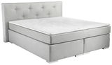 Boxspringbett in hellem Grau mit gestepptem Kopfteil, seitliche Perspektive