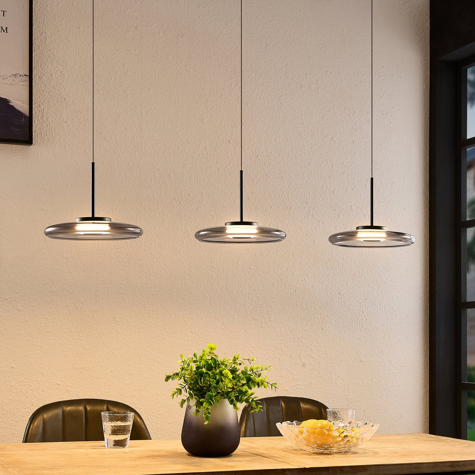 Novel LED-Hängeleuchte Drei moderne LED-Hängeleuchten in einer gemütlichen Esszimmerumgebung, von der Seite betrachtet.