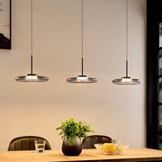 Drei moderne LED-Hängeleuchten in einer gemütlichen Esszimmerumgebung, von der Seite betrachtet.