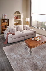 Gemütliches Big-Sofa in einem modernen Wohnzimmer, seitliche Perspektive mit großen Fenstern und stilvoller Dekoration.